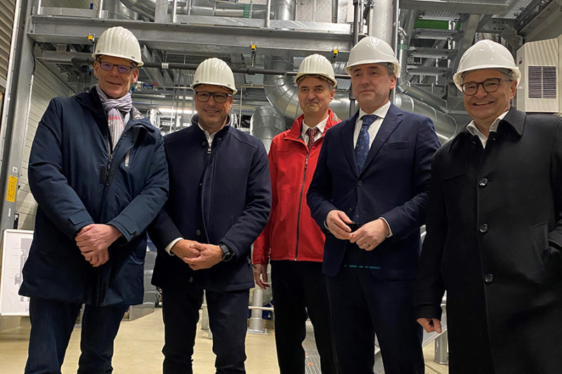 Akteure stehen vor der Anlage.