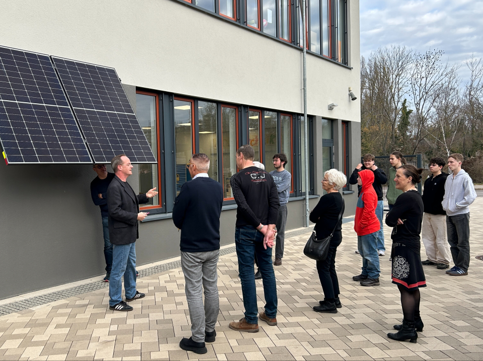 Herr Seimel erklärt die PV-Anlage. Schüler und Lehrer hören ihm gespannt zu. 