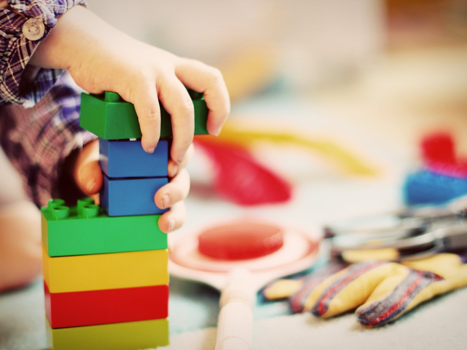 Kind baut einen Turm aus Legosteinen