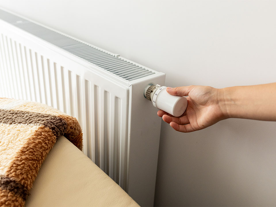 Eine Heizung wird an einem klassischen Heizungsthermostat eingestellt.